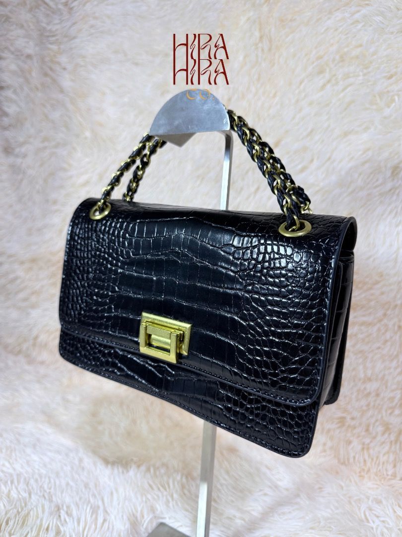 Black Crocodile Textured Shoulder Bag with Gold Hardware (Category: Shoulder Bags) located in Caloocan City. Submitted by hirahira.co (Listing ID 1467081344, Image 2). Description: - Elegant black shoulder bag with faux crocodile skin texture - Eye-catching gold-tone front clasp closure - Stylish woven black and gold chain strap - Clean interior featuring a convenient zipper pocket - Excellent, clean condition inside and out (comes packed with or