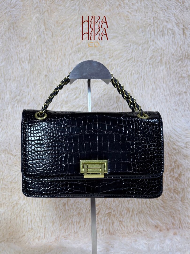 Black Crocodile Textured Shoulder Bag with Gold Hardware (Category: Shoulder Bags) located in Caloocan City. Submitted by hirahira.co (Listing ID 1467081344, Image 1). Description: - Elegant black shoulder bag with faux crocodile skin texture - Eye-catching gold-tone front clasp closure - Stylish woven black and gold chain strap - Clean interior featuring a convenient zipper pocket - Excellent, clean condition inside and out (comes packed with or