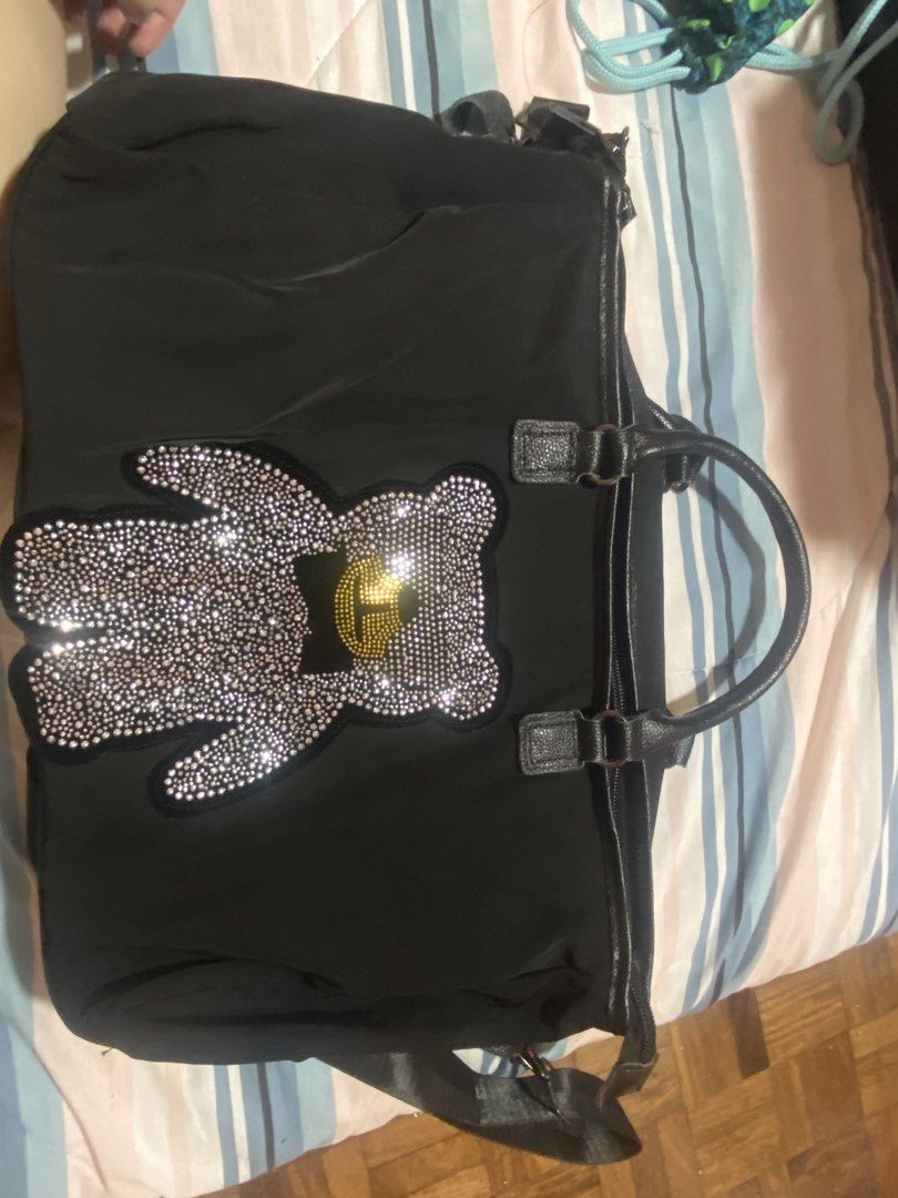 Black Handbag with Rhinestone Bear Design (Category: Shoulder Bags) located in Las Pinas. Submitted by 22nellie28 (Listing ID 1467065632, Image 1). Description: - Color & Material: Stylish black fabric - Design: Large rhinestone bear patch with a gold and black bow tie detail - Versatile Carry: Comes with top handles and an adjustable shoulder strap - Closure: Secure zipper closure across the top - Storage: Spacious interior, perfect for your dai