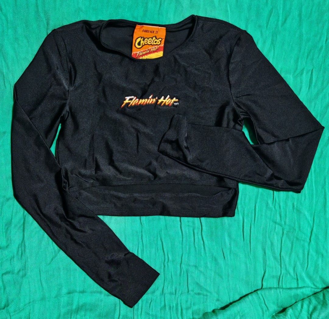 Black Mesh Long Sleeve Off Shoulder Crop Top (Category: Longsleeves) located in Paranaque City. Submitted by MLandCobyApple (Listing ID 1467031878, Image 2). Description: - Color: Black with red 'rock more' lettering - Style: Off-shoulder crop top with sheer mesh long sleeves - Details: Ruffled accents along the arms and cuffs - Fabric: Lightweight and comfortable - Condition: Good, worn a few times Buy one Get one.