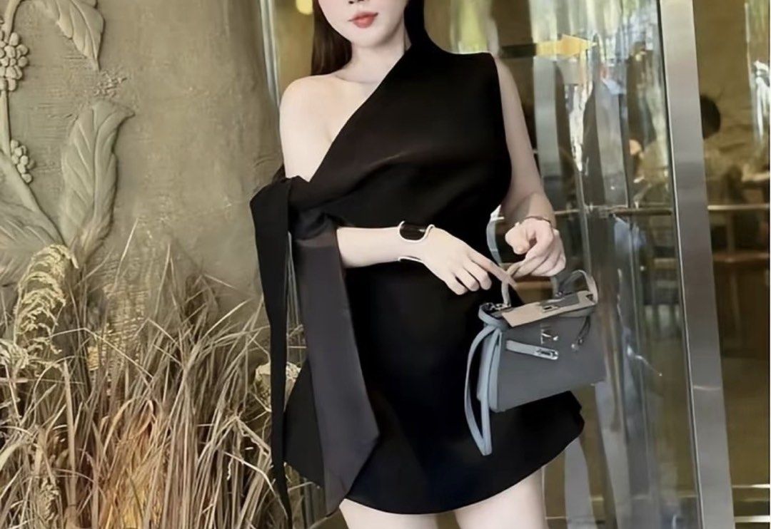 Black Mini Dress (Category: Dresses) located in Manila. Submitted by everythingwlove (Listing ID 1467030269, Image 1). Description: - Color: Sleek black - Design: Asymmetrical one-shoulder with a long sleeve and playful tie-up ribbon detail - Fit: Fitted bodice that flares gently into a short skirt - Material: Smooth fabric with a slight sheen - Condition: Worn a few times for dinners and events - Styling: Easy to dress up with heels and a mini b