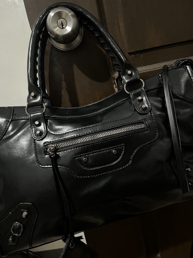 Black Motorcycle Bag with Silver Hardware (Category: Luxury Bags & Wallets) located in Mabalacat. Submitted by onlygrail.pamp (Listing ID 1467142897, Image 2). Description: - Color & Material: Premium black leather with edgy silver hardware and studded details - Versatile Carry: Includes dual rolled top handles and a detachable shoulder strap - Extra Storage & Perks: Convenient front zippered pocket with long leather pull tabs and a matching mini