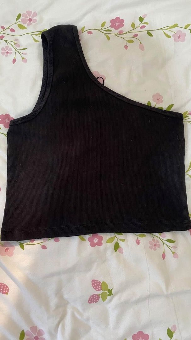 Black ribbed one-shoulder crop top (Category: Sleeveless) located in Caloocan City. Submitted by lianarchiveee (Listing ID 1467091800, Image 1). Description: - Color: Black - Design: Asymmetrical one-shoulder, ribbed texture - Fit: Stretchy, comfortable, cropped length - Style: Versatile basic piece - Pairing: Great with high-waisted jeans or skirts.