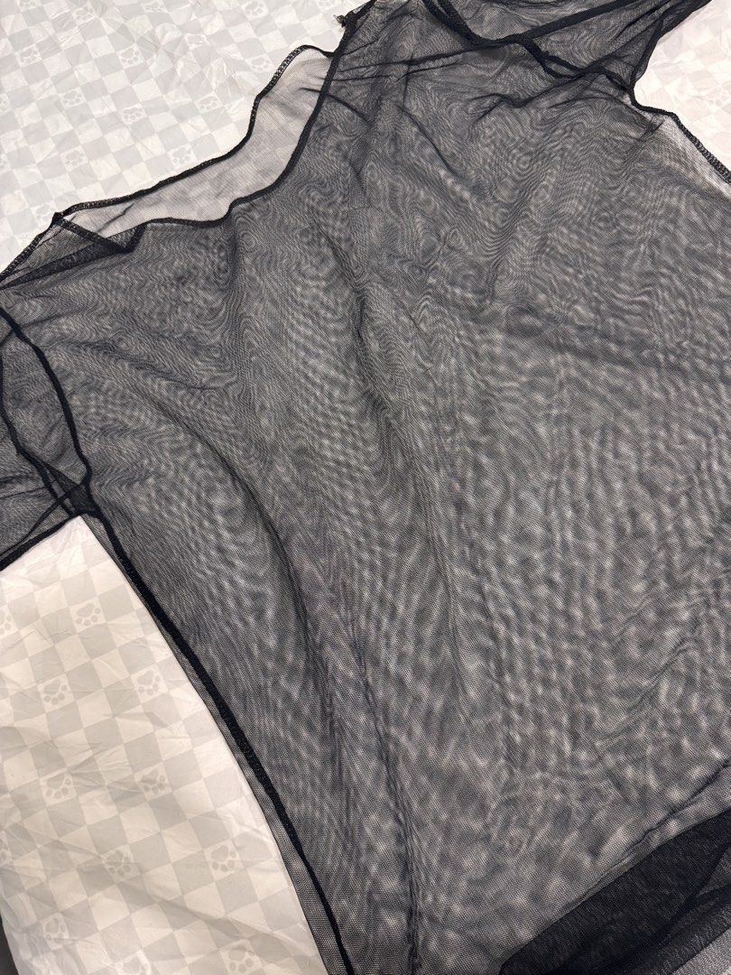 Black Sheer Mesh T-Shirt (Category: Shirts) located in Cavite. Submitted by zealtree.39df52 (Listing ID 1467111332, Image 2). Description: - Color: Black - Material: Lightweight sheer mesh - Fit: Slightly oversized with a relaxed neckline and short sleeves - Styling: Great for layering over bralettes or camisoles - Occasion: Versatile for casual outfits or nights out - Condition: Clean and ready to wear.