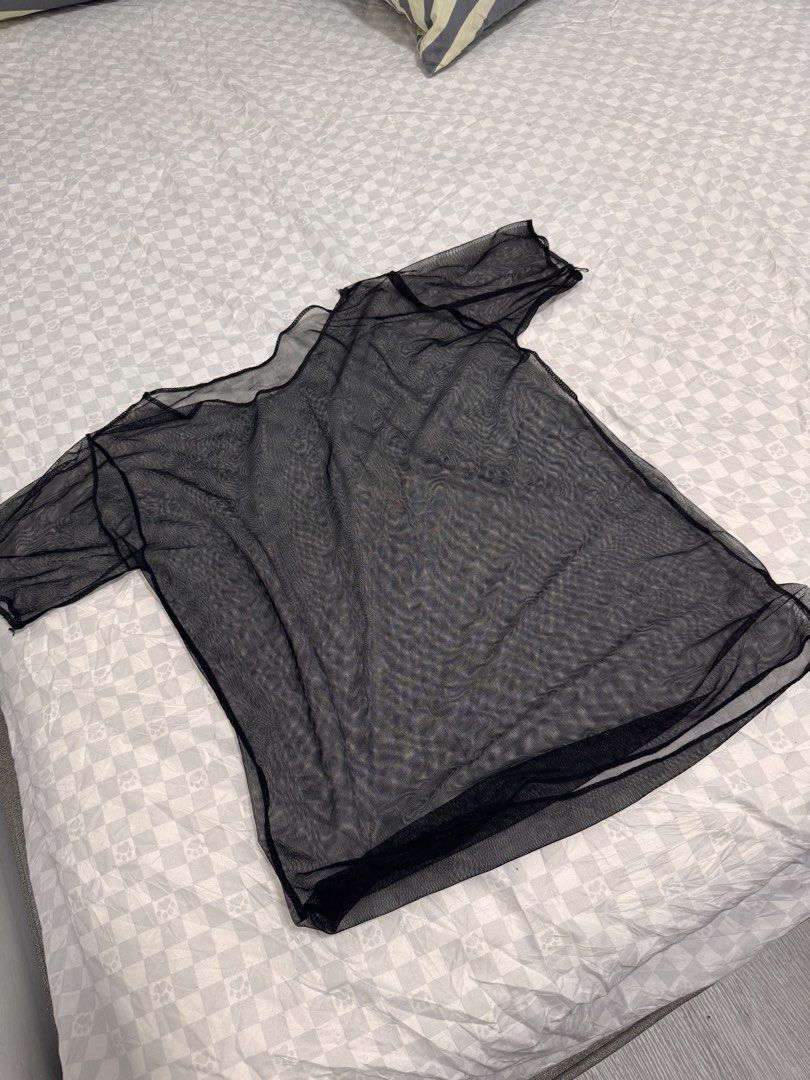 Black Sheer Mesh T-Shirt (Category: Shirts) located in Cavite. Submitted by zealtree.39df52 (Listing ID 1467111332, Image 1). Description: - Color: Black - Material: Lightweight sheer mesh - Fit: Slightly oversized with a relaxed neckline and short sleeves - Styling: Great for layering over bralettes or camisoles - Occasion: Versatile for casual outfits or nights out - Condition: Clean and ready to wear.