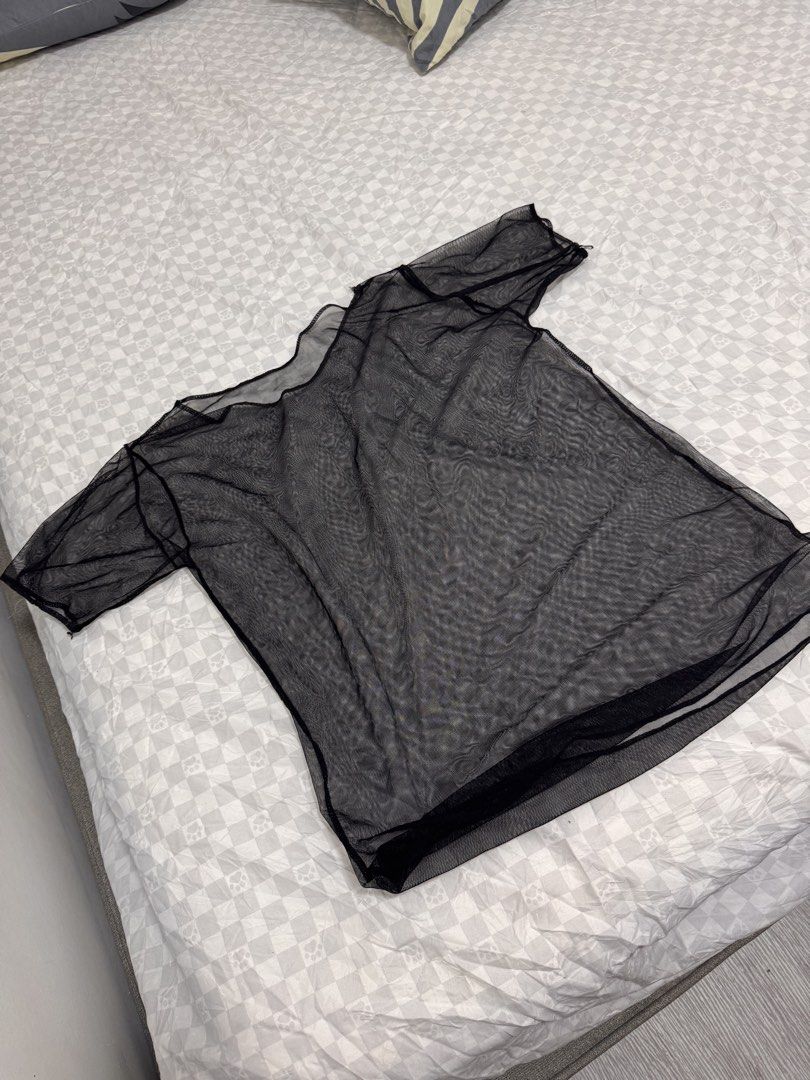 Black Sheer Mesh T-Shirt (Category: Shirts) located in Cavite. Submitted by zealtree.39df52 (Listing ID 1467111332, Image 3). Description: - Color: Black - Material: Lightweight sheer mesh - Fit: Slightly oversized with a relaxed neckline and short sleeves - Styling: Great for layering over bralettes or camisoles - Occasion: Versatile for casual outfits or nights out - Condition: Clean and ready to wear.