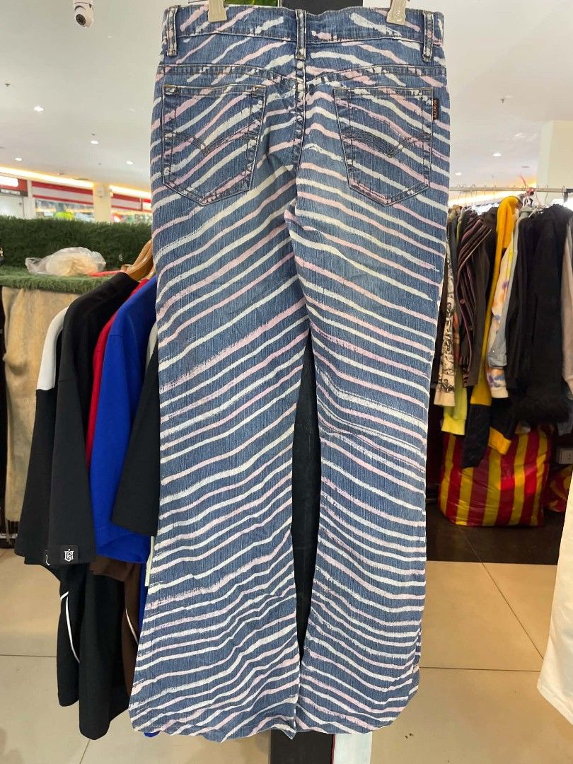 Blue and pink striped denim flared jeans (Category: Jeans) located in Cainta. Submitted by riszizlux (Listing ID 1467069374, Image 2). Description: - Style: Streetwear statement flared jeans - Pattern: Eye-catching diagonal white and pink stripes on blue denim - Features: Standard front and back pockets, button and zip closure - Fit: Flared leg cut - Condition: Excellent, ready to wear - Note: Check tape label on waistband for size details (Messa