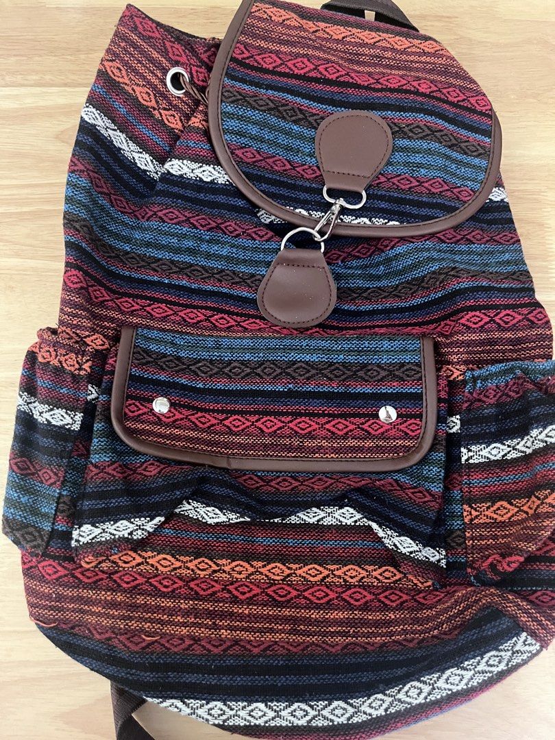 Boho Woven Pattern Backpack with Brown Straps (Category: Backpacks) located in Manila. Submitted by freecrystal.28ce36 (Listing ID 1467000852, Image 1). Description: - Style: Boho chic with vibrant multicolored stripes (red, orange, blue, and black) - Material: Colorful woven fabric with brown faux-leather trim - Straps: Comfortable brown adjustable shoulder straps - Closure: Drawstring top for the main compartment plus a front flap pocket with a