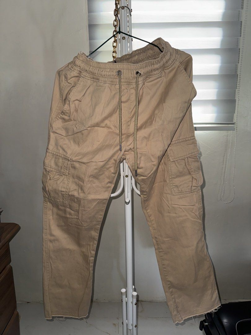 boohooMAN Khaki Cargo Pants Size 30 (Category: Trousers) located in La Trinidad. Submitted by prelovedandfindsbyji (Listing ID 1466981410, Image 1). Description: - Brand: boohooMAN - Size: 30 - Color: Khaki (Neutral earth tone) - Material: Sturdy cotton fabric - Fit: Relaxed fit through the legs - Waistband: Elastic with drawstring closure - Details: Multiple side utility pockets and raw hem cuffs - Condition: Brand new / Excellent.