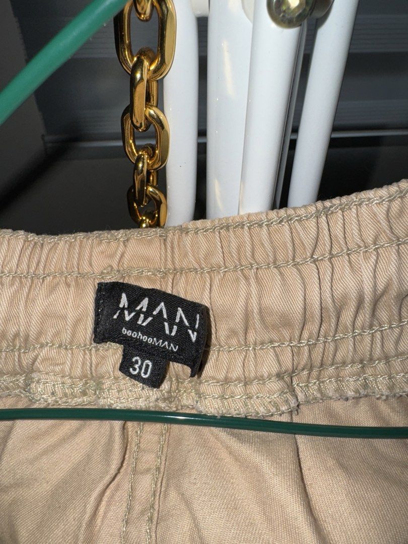 boohooMAN Khaki Cargo Pants Size 30 (Category: Trousers) located in La Trinidad. Submitted by prelovedandfindsbyji (Listing ID 1466981410, Image 3). Description: - Brand: boohooMAN - Size: 30 - Color: Khaki (Neutral earth tone) - Material: Sturdy cotton fabric - Fit: Relaxed fit through the legs - Waistband: Elastic with drawstring closure - Details: Multiple side utility pockets and raw hem cuffs - Condition: Brand new / Excellent.