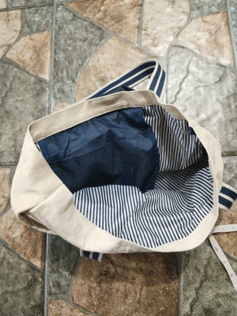 Brooks Brothers Tote Bag (Category: Tote Bags) located in Legazpi City. Submitted by genobecollectives (Listing ID 1467078372, Image 3). Description: Brooks Brothers tote bag 500 free ship - Color: Cream with dark blue accents and faux leather bottom - Design: Stylish blue and white striped shoulder straps - Interior: Spacious with matching striped lining - Size: Measures approximately 15 x 16 - Condition: Clean canvas body, light scratch sa iban