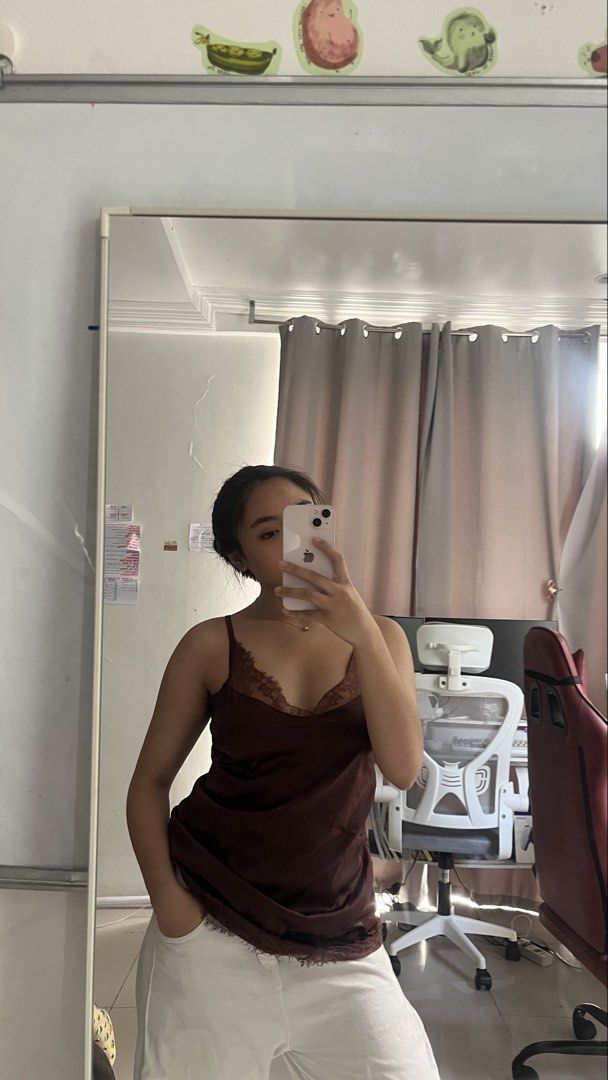 Brown Lace Trim Satin Camisole (Category: Sleeveless) located in Manila. Submitted by iayo.15 (Listing ID 1467059959, Image 1). Description: - Color: Deep brown - Material: Soft satin with a slight sheen - Details: Delicate lace trimming along the V-neckline - Fit: Relaxed fit, easy to tuck in or wear loose - Styling: Pairs perfectly with white bottoms for a chic daytime look - Condition: Clean and ready to wear.