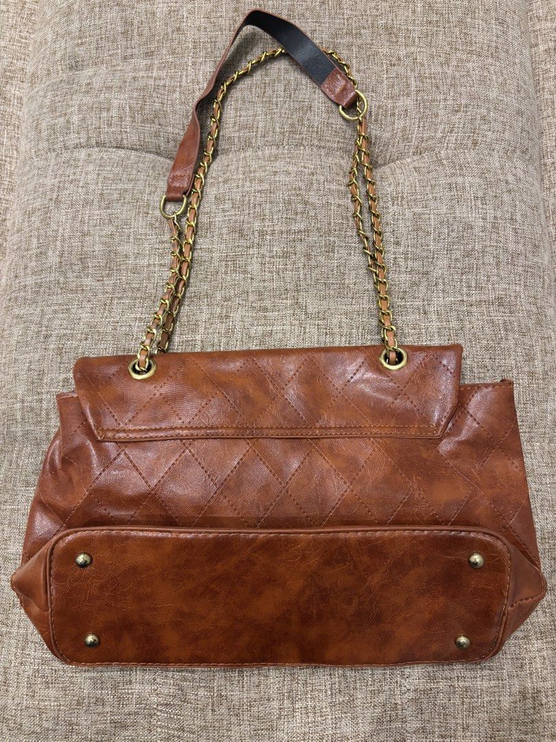Brown Quilted Shoulder Bag with Gold Chain (Category: Shoulder Bags) located in Makati City. Submitted by bittersweet818ta (Listing ID 1467133887, Image 2). Description: - Color: Brown - Material: Quilted design with dark brown fabric lining - Straps: Gold chain straps with comfortable leather shoulder guards - Closure: Flap top with a secure rectangular twist lock - Interior: Main compartment divided by a convenient zip pocket - Protection: Stru