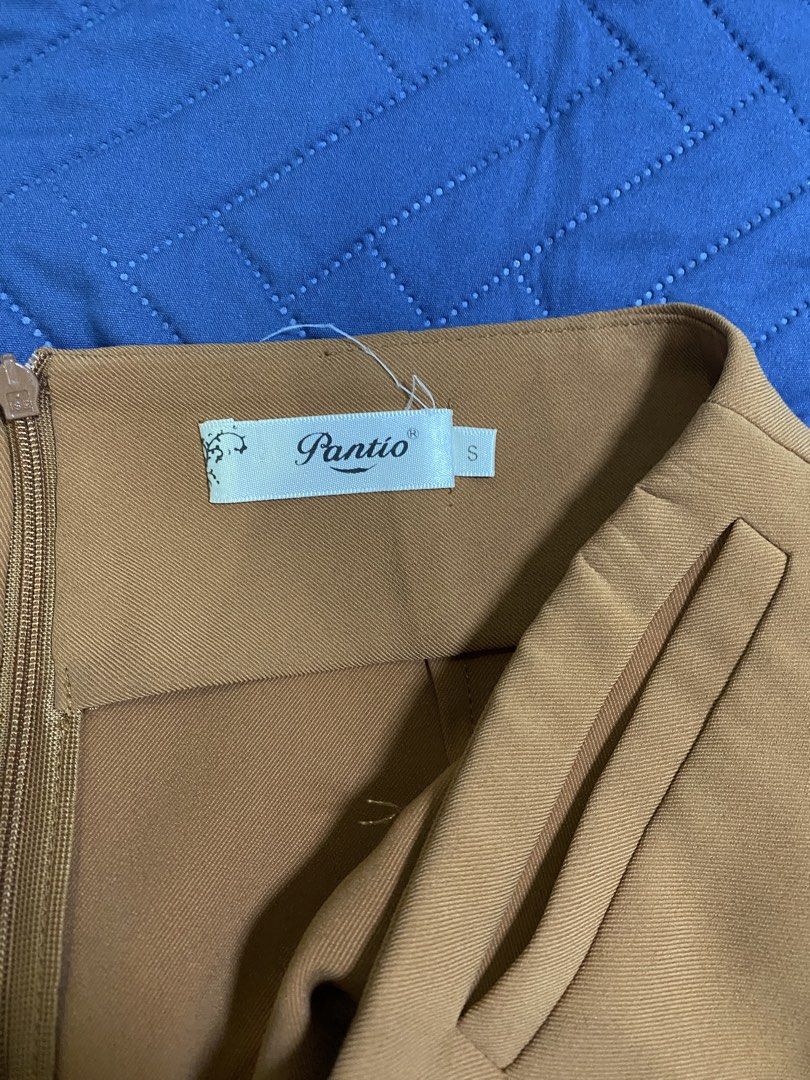 Brown Wrap Skirt Size S (Category: Skirts) located in Manila. Submitted by escherichiaa (Listing ID 1467139698, Image 2). Description: - Brand: Pantio - Size: Small - Color: Brown - Material: Textured twill weave - Features: Front flap overlay with built-in belt loop and strap accent, side zipper closure - Style: Great for work or casual outings - Condition: Excellent.