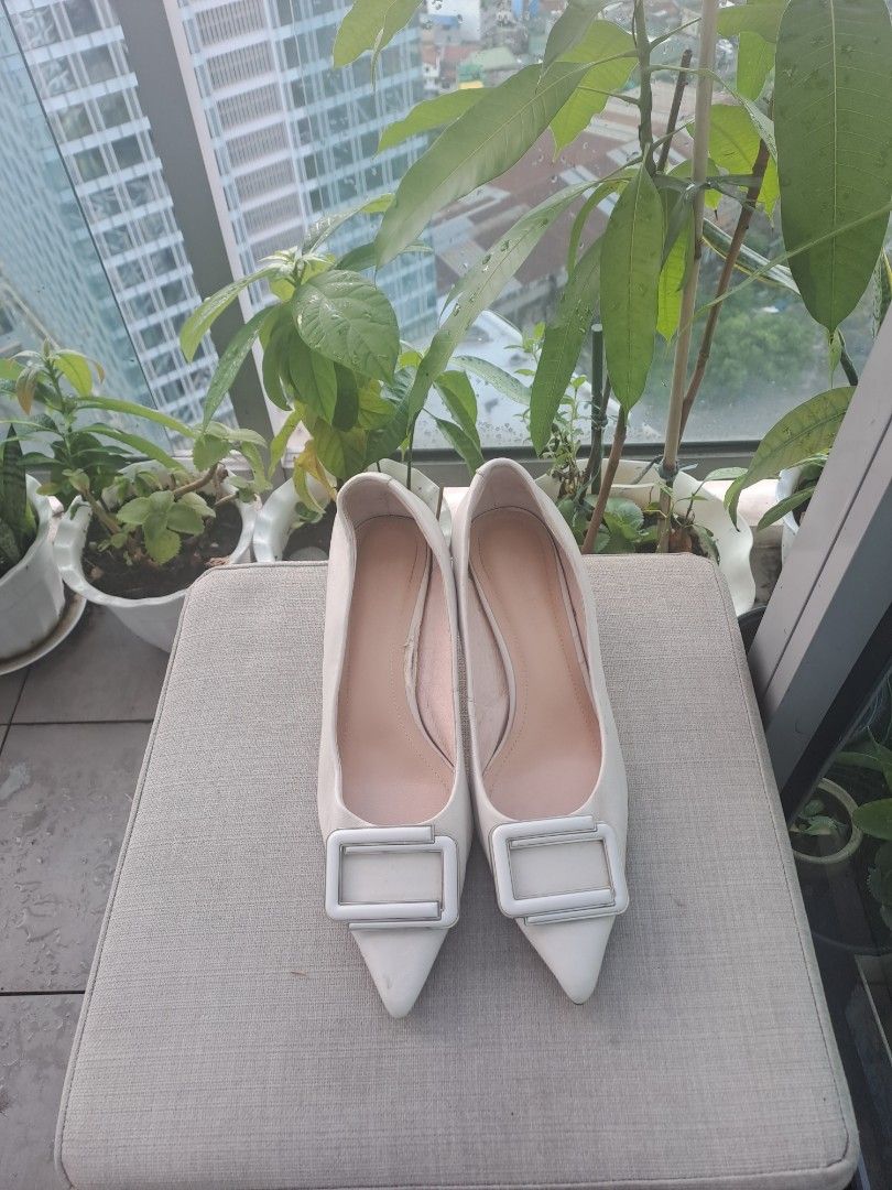 C banner pointed heels (Category: Heels) located in Manila. Submitted by joanbalde39643 (Listing ID 1467037313, Image 2). Description: The image displays a pair of elegant, off-white pointed-toe pump heels accented with a distinct square buckle detail across the vamp. They feature a low to mid-height kitten/stiletto heel, making them versatile for both formal settings and smart-casual styling..