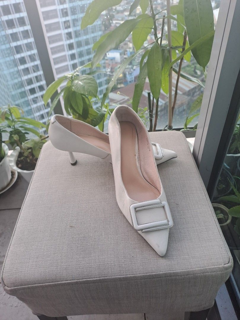 C banner pointed heels (Category: Heels) located in Manila. Submitted by joanbalde39643 (Listing ID 1467037313, Image 1). Description: The image displays a pair of elegant, off-white pointed-toe pump heels accented with a distinct square buckle detail across the vamp. They feature a low to mid-height kitten/stiletto heel, making them versatile for both formal settings and smart-casual styling..