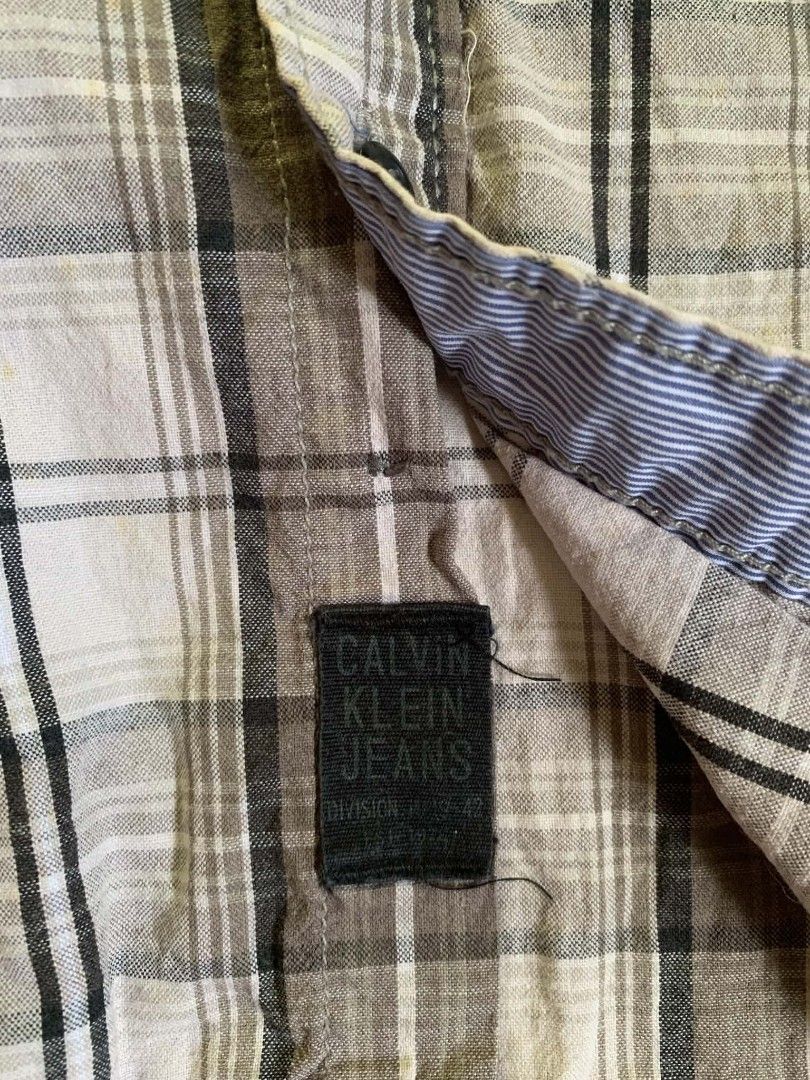 Calvin Klein Jeans Plaid Button-Down Shirt Size S (Category: Sleep and Loungewear) located in Tiaong. Submitted by cdoswan (Listing ID 1467038485, Image 2). Description: - Brand: Calvin Klein Jeans - Style: Long-sleeve button-down shirt - Size: S - Color/Pattern: Brown and white plaid - Details: Two button-flap chest pockets, contrast blue and white striped fabric inside collar and cuffs - Origin: Made in China - Condition: Excellent pre-loved co