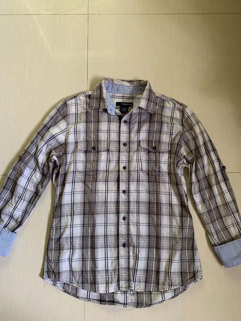 Calvin Klein Jeans Plaid Button-Down Shirt Size S (Category: Sleep and Loungewear) located in Tiaong. Submitted by cdoswan (Listing ID 1467038485, Image 1). Description: - Brand: Calvin Klein Jeans - Style: Long-sleeve button-down shirt - Size: S - Color/Pattern: Brown and white plaid - Details: Two button-flap chest pockets, contrast blue and white striped fabric inside collar and cuffs - Origin: Made in China - Condition: Excellent pre-loved co