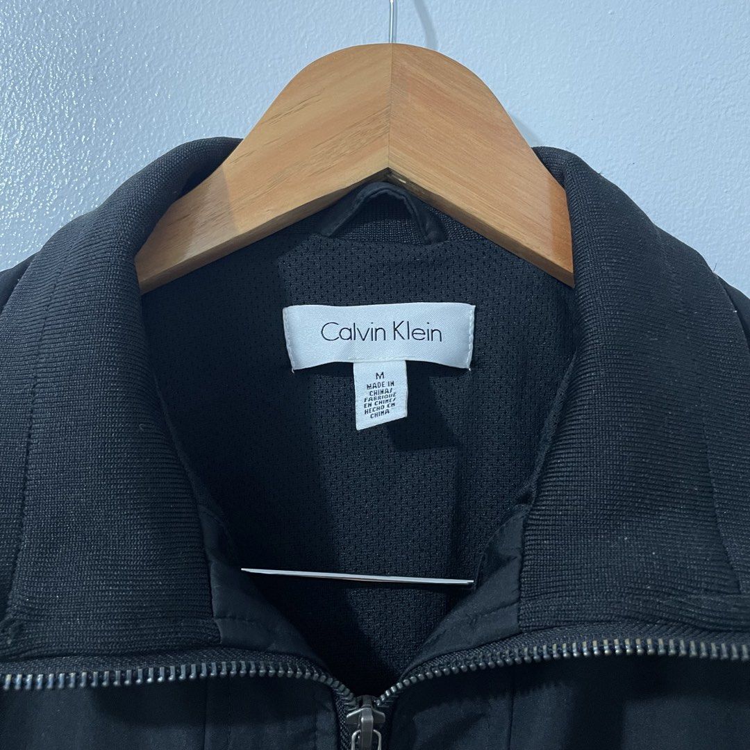Calvin Klein Men's Zip Up Jacket (Medium) (Category: Coats, Jackets and Outerwear) located in Quezon City. Submitted by 2h3nji (Listing ID 1467013111, Image 2). Description: Calvin Klein Men's Zip Up Jacket • Medium (Can fit to Large) • 23x27 • Black • 10/10 color rate • Good as new • No issues 1,500💵 Tandang Sora, QC📍.