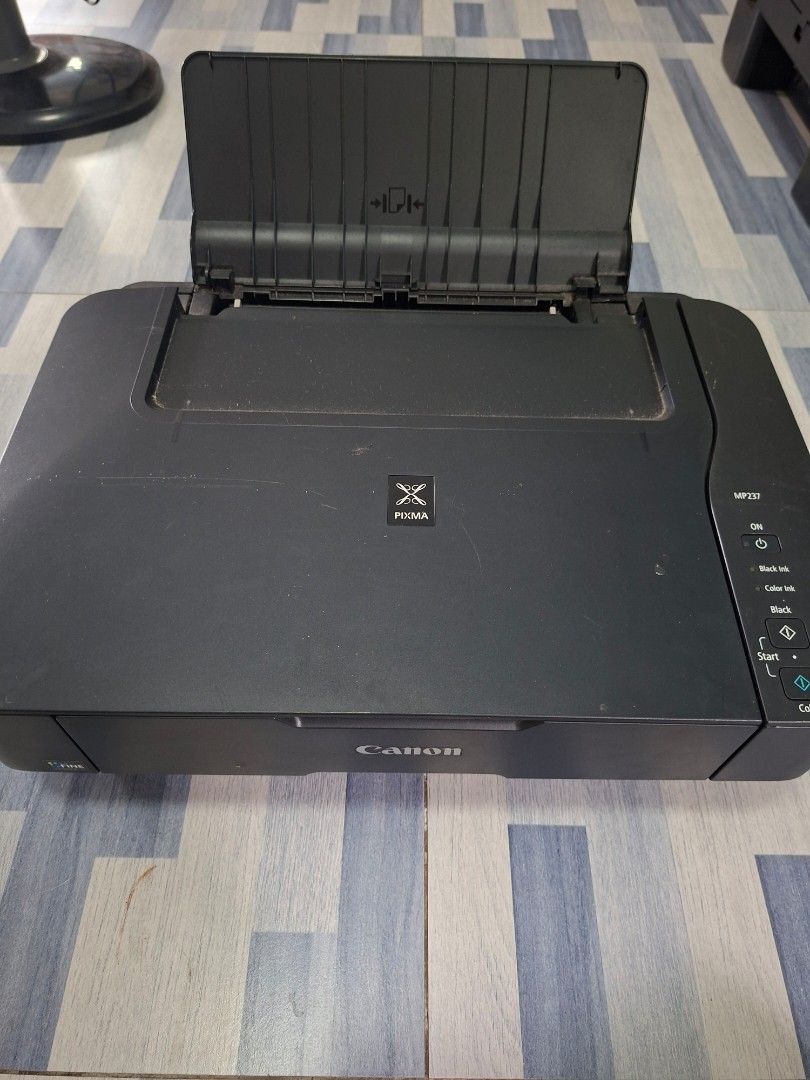 Canon Pixma MP237 Printer (Category: Printers, Scanners & Copiers) located in Manila. Submitted by ninyagauri24333 (Listing ID 1467011538, Image 1). Description: - Model: Canon Pixma MP237 Multi-Function Inkjet Printer - Color: Sleek Black - Condition: Powers on via top button, fully functional flatbed printer/scanner - Features: Top panel with easy-to-use buttons and indicator lights - Design: Convenient paper tray attached on the left side - Pe