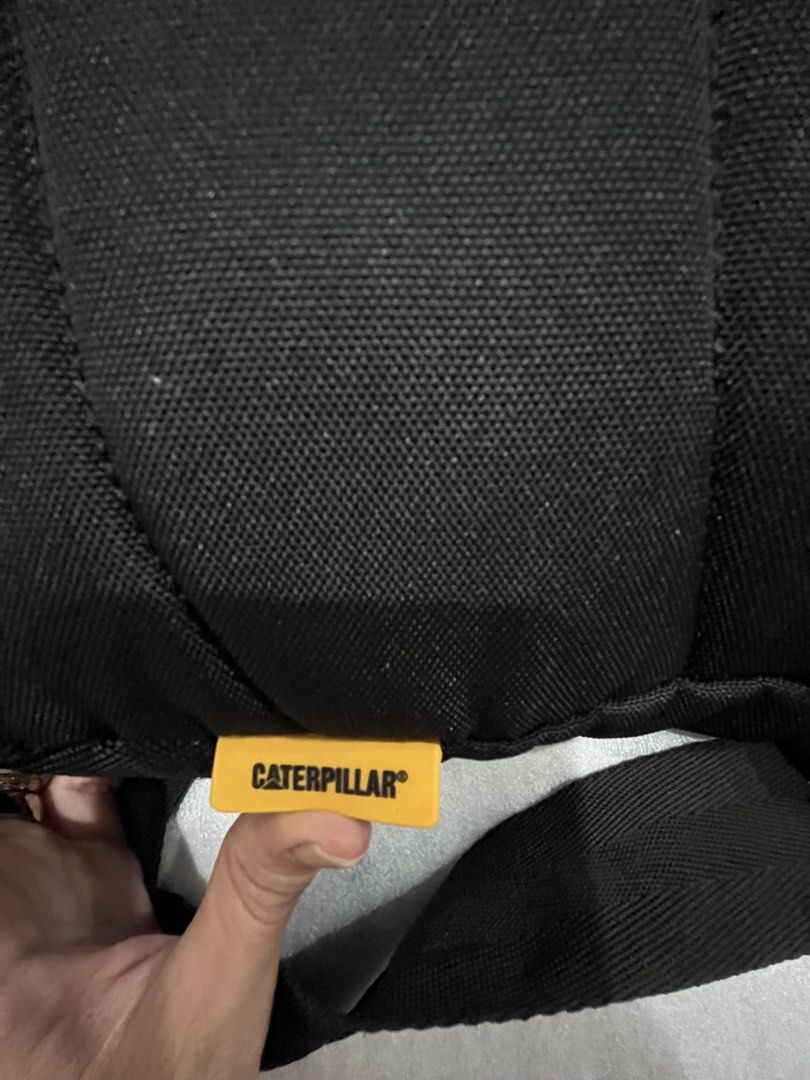 Caterpillar CAT Black Messenger Crossbody Bag (Category: Sling Bags) located in Talisay. Submitted by cherylu (Listing ID 1466975549, Image 3). Description: Black CAT crossbody bag made from sturdy canvas material. Features a large front zipped compartment and adjustable shoulder strap. Interior lined with black fabric and branded Caterpillar logo patch inside and outside. Yellow CATERPILLAR tag attached on the side. Great everyday bag for carryi