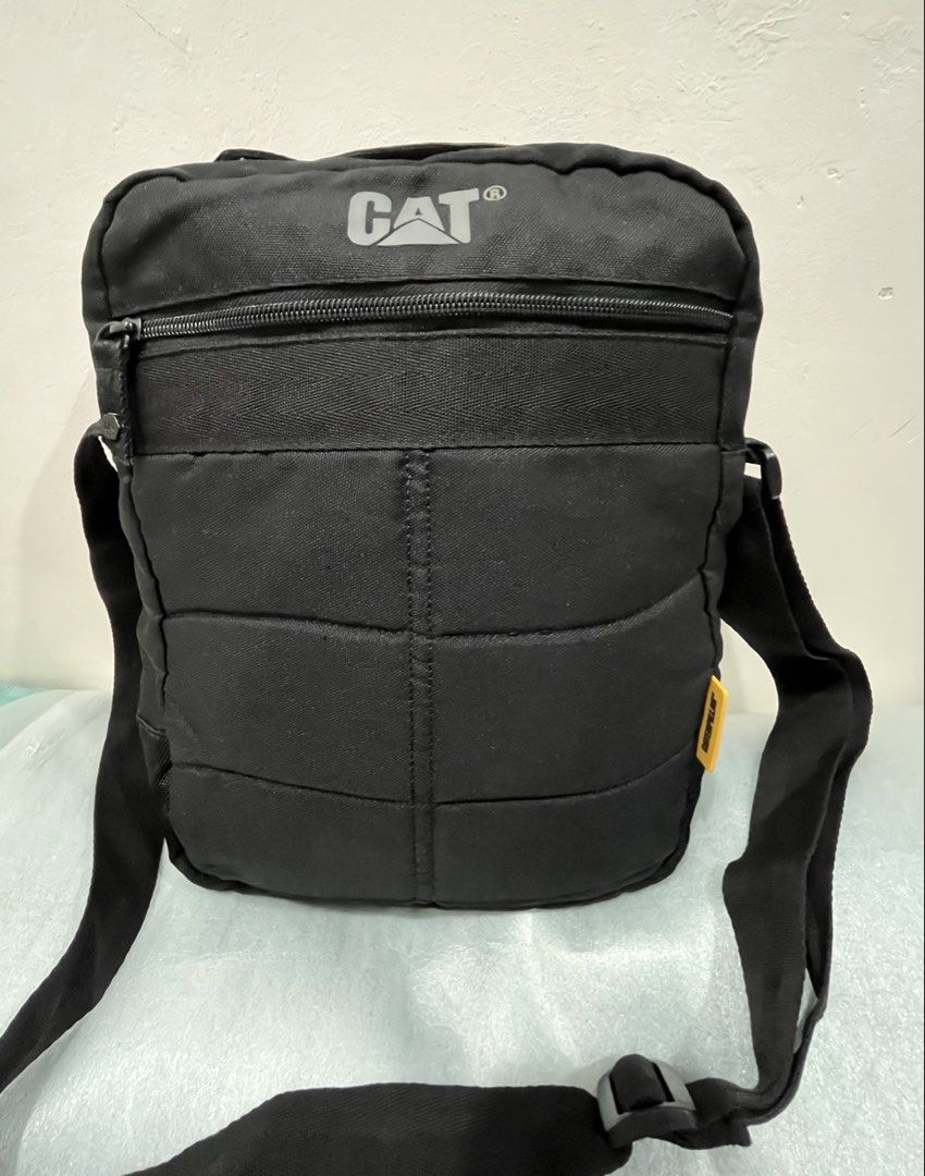 Caterpillar CAT Black Messenger Crossbody Bag (Category: Sling Bags) located in Talisay. Submitted by cherylu (Listing ID 1466975549, Image 1). Description: Black CAT crossbody bag made from sturdy canvas material. Features a large front zipped compartment and adjustable shoulder strap. Interior lined with black fabric and branded Caterpillar logo patch inside and outside. Yellow CATERPILLAR tag attached on the side. Great everyday bag for carryi