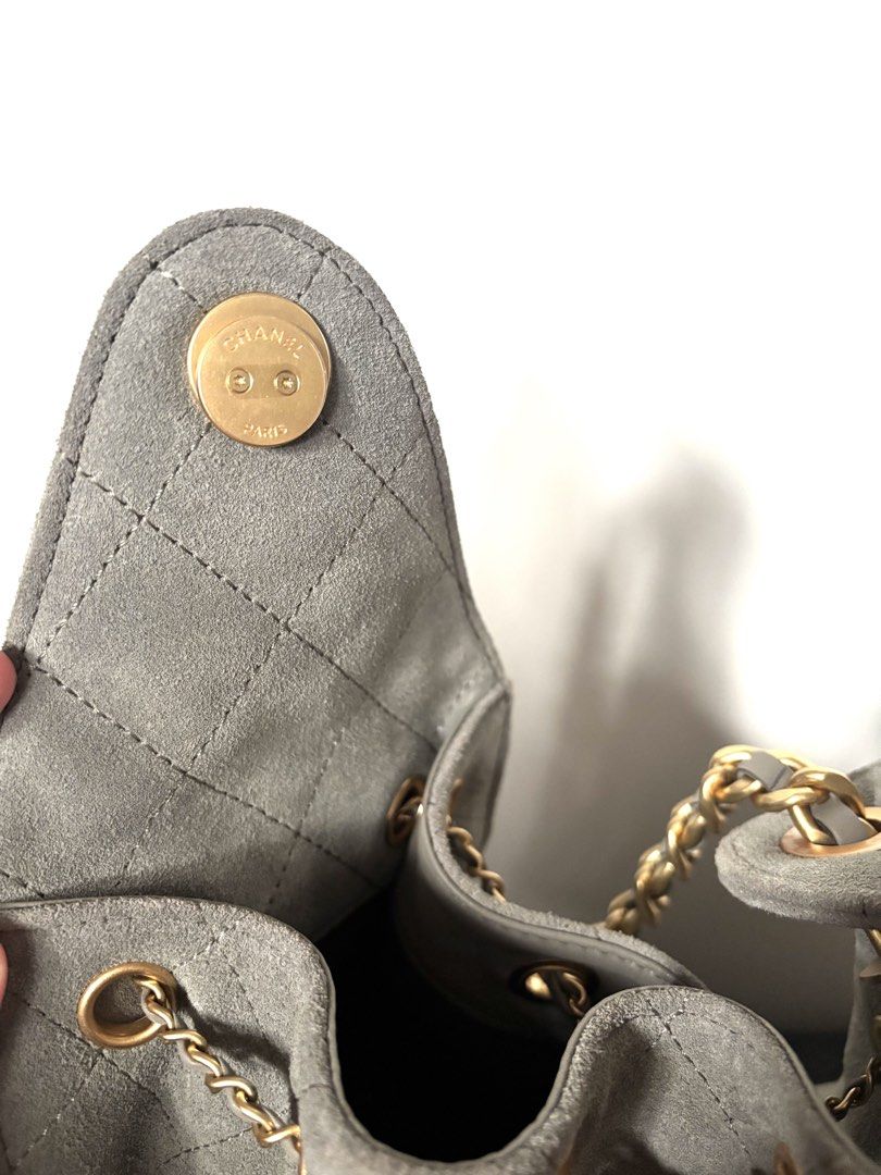 Chanel 25 Suede Bag Gold Hardware Grey (Category: Luxury Bags & Wallets) located in Navotas City. Submitted by carla.lololomo (Listing ID 1467010182, Image 3). Description: - Chanel bucket bag - Material: Quilted suede in grey - Hardware: Gold-tone chain straps and CC twist-lock closure - Interior: Dark fabric lining with wall pocket and 'Chanel Made in Italy' leather tag - Closure: Flap with magnetic snap button (Chanel Paris stamped) - Inclusio