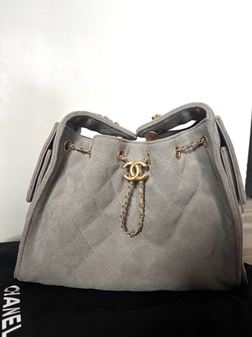 Chanel 25 Suede Bag Gold Hardware Grey (Category: Luxury Bags & Wallets) located in Navotas City. Submitted by carla.lololomo (Listing ID 1467010182, Image 1). Description: - Chanel bucket bag - Material: Quilted suede in grey - Hardware: Gold-tone chain straps and CC twist-lock closure - Interior: Dark fabric lining with wall pocket and 'Chanel Made in Italy' leather tag - Closure: Flap with magnetic snap button (Chanel Paris stamped) - Inclusio