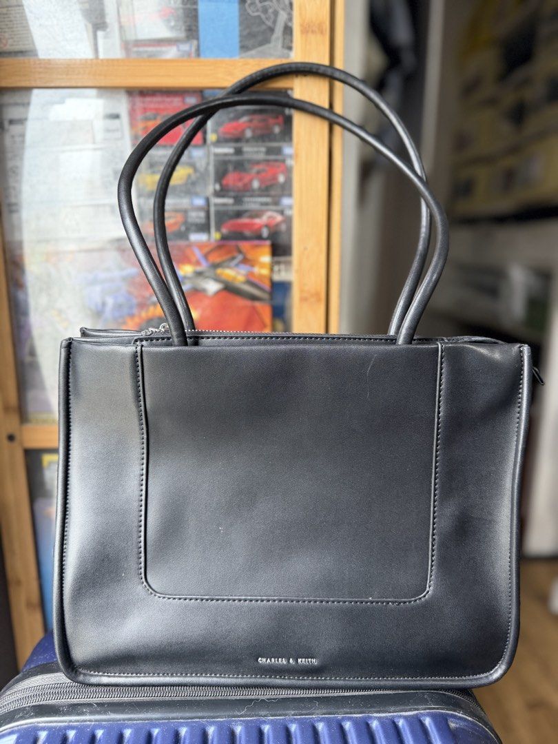 Charles & Keith Black Tote Bag (Category: Tote Bags) located in Dasmarinas. Submitted by mspigrabbit (Listing ID 1467033010, Image 1). Description: - Brand: Charles & Keith - Color: Classic black with contrast stitching - Hardware: Silver-tone with branded zipper pull - Closure: Secure top zip - Straps: Comfortable dual shoulder straps - Storage: Roomy interior for phone, wallet, keys, and daily essentials - Style: Versatile structured tote, grea