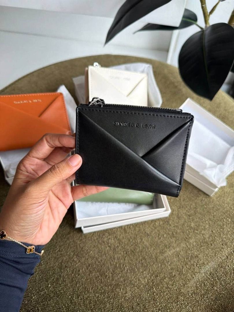 Charles & Keith Envelope Cardholder Wallet (Category: Wallets & Card holders) located in Manila. Submitted by liahsells (Listing ID 1467036478, Image 2). Description: - Brand: Charles & Keith - Design: Envelope style with zip top closure and embossed logo - Colors Available: Sage green, black, brown, and off-white - Size: Compact, pocket-friendly, ideal for daily essentials - Inclusions: Comes with original white packaging box - Condition: Brand 