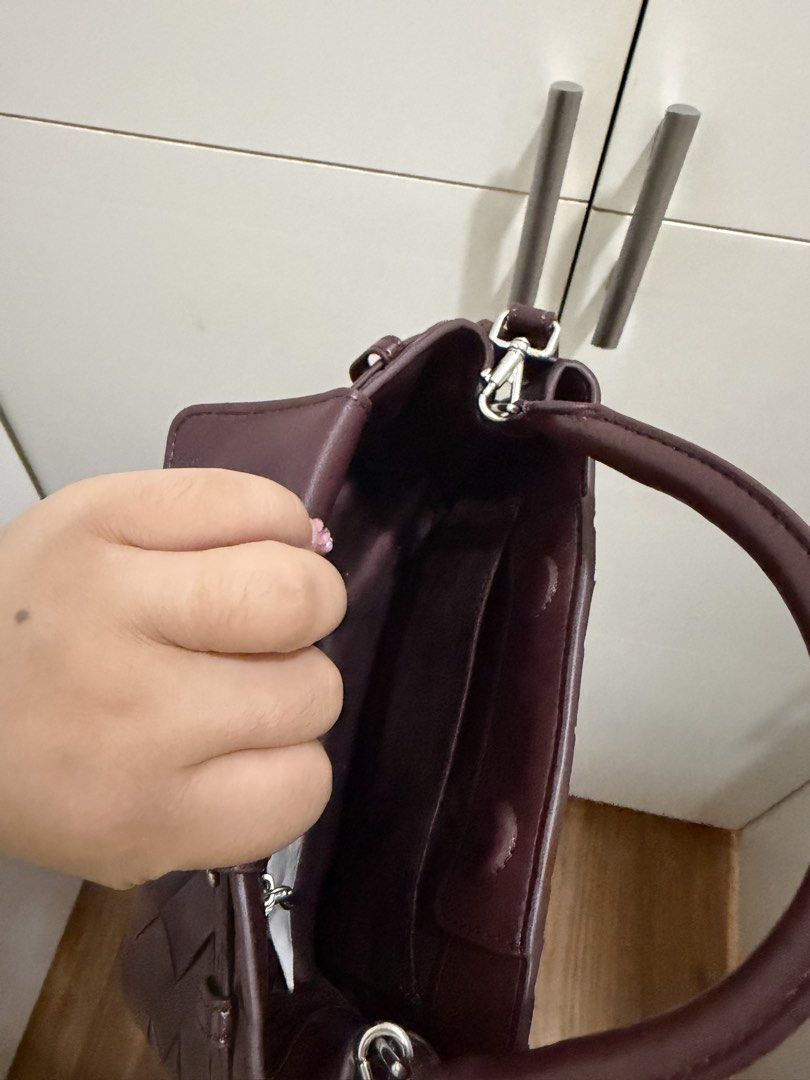 Charles & Keith Interwoven Burgundy Handbag (Category: Luxury Bags & Wallets) located in Davao. Submitted by pamdyclutters (Listing ID 1467140927, Image 3). Description: - Brand: Charles & Keith - Color: Rich Burgundy with silver-toned hardware and studs - Design: Stylish woven pattern across the body - Versatility: Includes a sturdy top handle and a removable shoulder strap - Extras: Features a chic branded luggage tag on the side ring - Interio