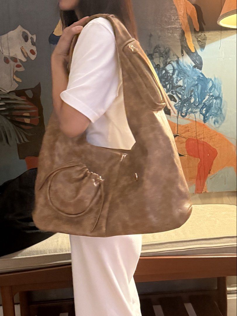 Chautifth Brown Leather Shoulder Bag (Category: Shoulder Bags) located in Makati City. Submitted by katvtorre (Listing ID 1467071960, Image 1). Description: - Brand: Chautifth - Material: Light brown faux leather - Design: Large, slouchy shape with a comfortable thick strap - Extra Storage: Small round drawstring pouch on the front & diagonal zippered pocket on the upper right strap - Inclusions: Comes with original Chautifth branded cream dust b