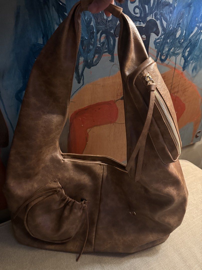 Chautifth Brown Leather Shoulder Bag (Category: Shoulder Bags) located in Makati City. Submitted by katvtorre (Listing ID 1467071960, Image 3). Description: - Brand: Chautifth - Material: Light brown faux leather - Design: Large, slouchy shape with a comfortable thick strap - Extra Storage: Small round drawstring pouch on the front & diagonal zippered pocket on the upper right strap - Inclusions: Comes with original Chautifth branded cream dust b