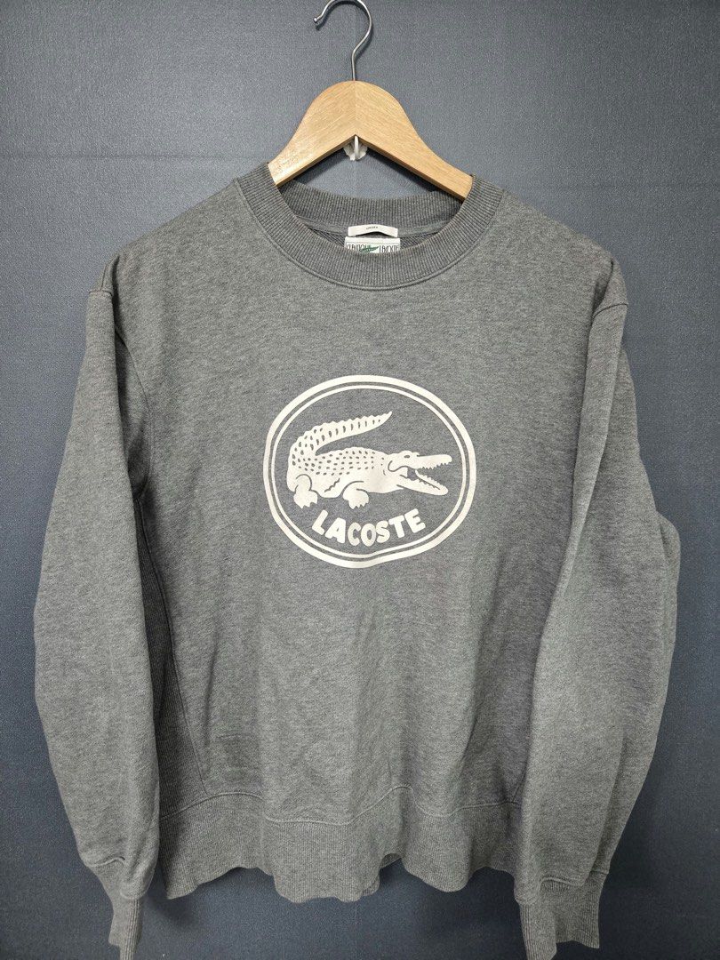 Classique Lacoste Unisex Grey Sweatshirt (Category: Coats, Jackets and Outerwear) located in Tarlac. Submitted by adivans (Listing ID 1466973016, Image 1). Description: - Brand: Lacoste - Style: Classic crewneck sweatshirt - Color: Grey - Size: Large (Unisex fit) - Material: Heavy cotton fleece - Details: Large circular crocodile chest graphic, ribbed cuffs, collar, and hem - Condition: Great for casual layering.