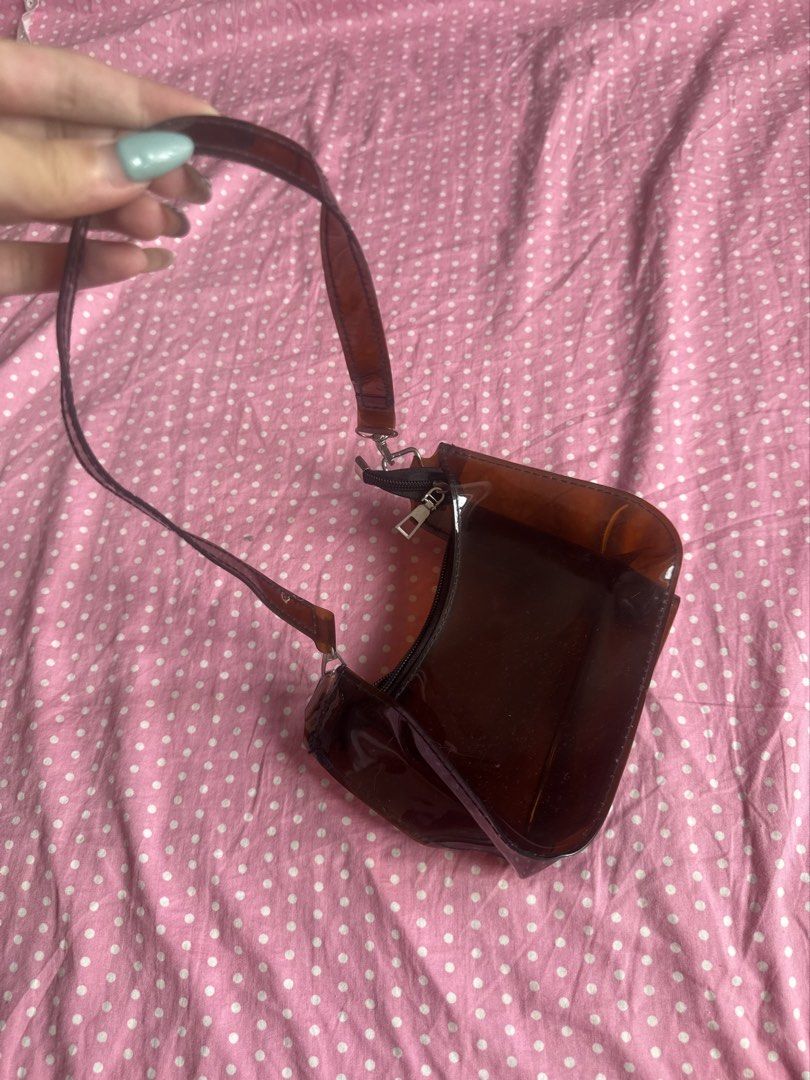 Clear brown plastic shoulder bag (Category: Shoulder Bags) located in Manila. Submitted by gkamille01 (Listing ID 1467011338, Image 2). Description: - Color/Material: Brown translucent plastic with a glossy finish - Design: Structured shape with silver hardware - Closure: Top zipper closure - Size: Compact, fits small daily essentials - Style: Great everyday shoulder bag 🚚 Buyer shoulders the shipping fee. Manila-based. 📍 Meet-ups available at 