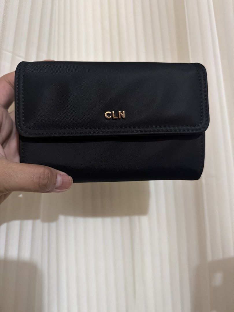 CLN Black Wallet with Gold Logo (Category: Wallets & Card holders) located in San Juan City. Submitted by thisismeely (Listing ID 1467168056, Image 1). Description: - Brand: CLN - Color: Black with gold-tone hardware and elegant lettering - Material: Durable fabric with stylish leather trim - Interior: Multiple card slots, clear ID window, and a secure zippered compartment - Condition: Brand new with tag still attached inside the coin pocket - Li