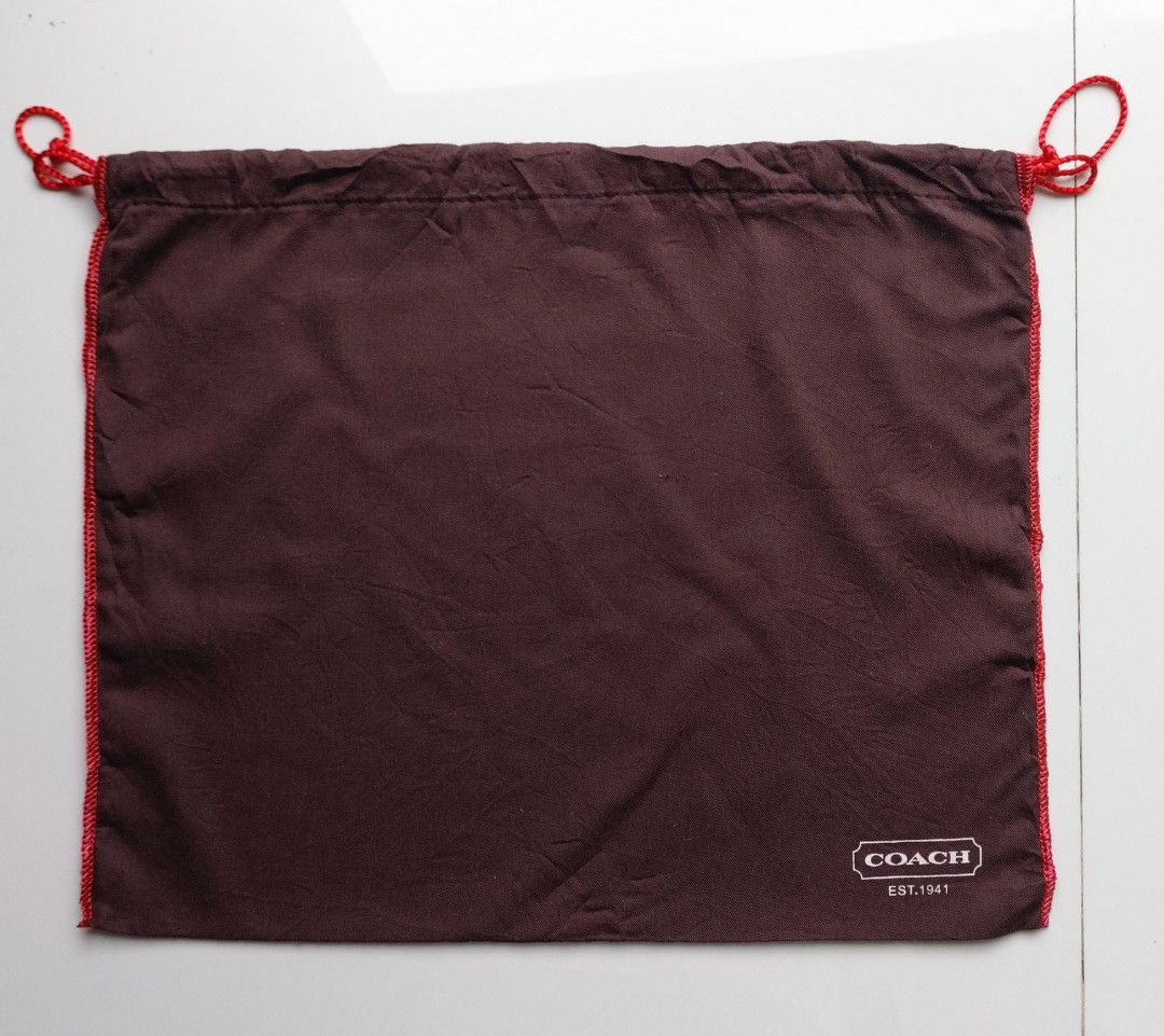 Coach Dust Bag Brown Red Drawstring (Category: Luxury Bags & Wallets) located in Lapu Lapu. Submitted by agnesapm_29813 (Listing ID 1467108783, Image 2). Description: - Authentic Coach dust bag in dark brown fabric - Features stylish red contrast stitching and red drawstring closure - White Coach EST. 1941 logo printed near the bottom corner - Measurements: width-16 inches, length-13 inches .