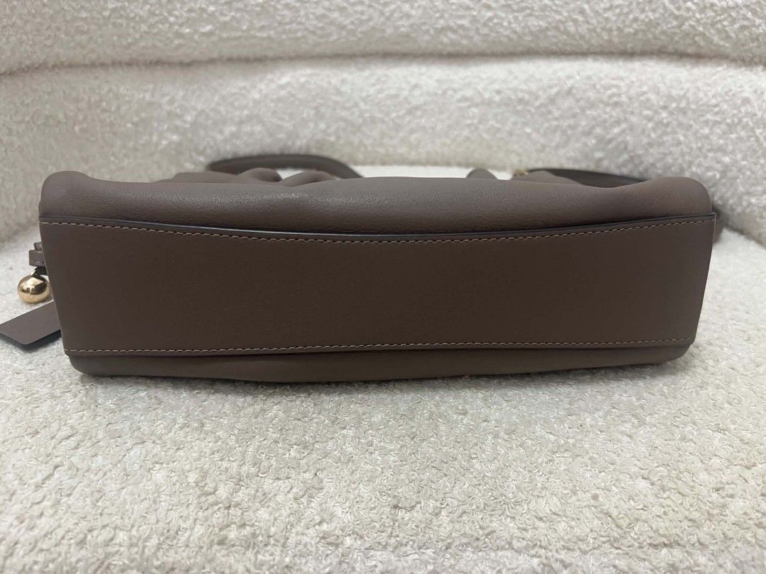 Coach Faye Shoulder Bag with Sling (Category: Shoulder Bags) located in Paoay. Submitted by rvf1230 (Listing ID 1467036081, Image 3). Description: Coach shoulder bag in rich brown leather. Gathered ruching detail along the top. Gold-tone hardware and Coach logo on the front. Includes main shoulder strap plus an extra adjustable crossbody strap. Inside features fabric lining, zippered pocket, and magnetic snap closure. Original store tags and rece