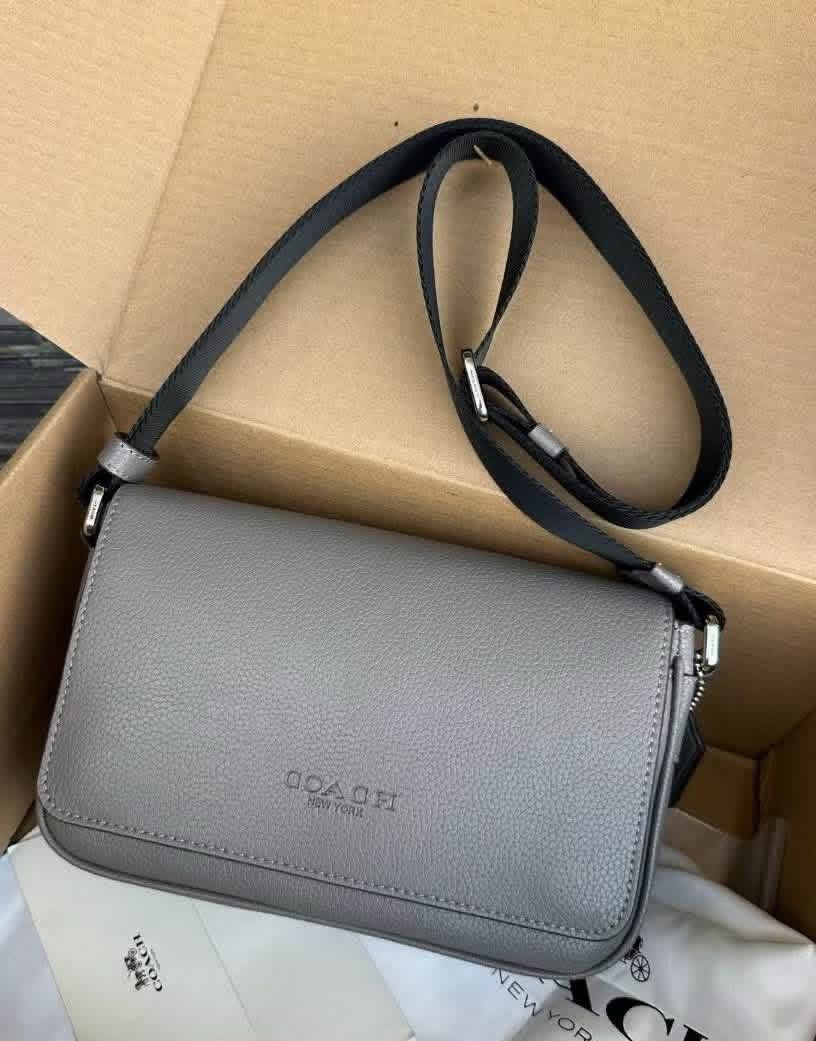 Coach Grey Leather Crossbody Bag (Category: Sling Bags) located in Manila. Submitted by bagsandmanymanymore1 (Listing ID 1466986863, Image 1). Description: - Authentic Coach crossbody bag in grey pebbled leather - Adjustable black fabric strap for comfortable wear - Secure magnetic snap closure with front flap and embossed Coach logo - Silver-tone hardware and neat contrast stitching - Soft suede-lined interior with convenient slip pockets and le