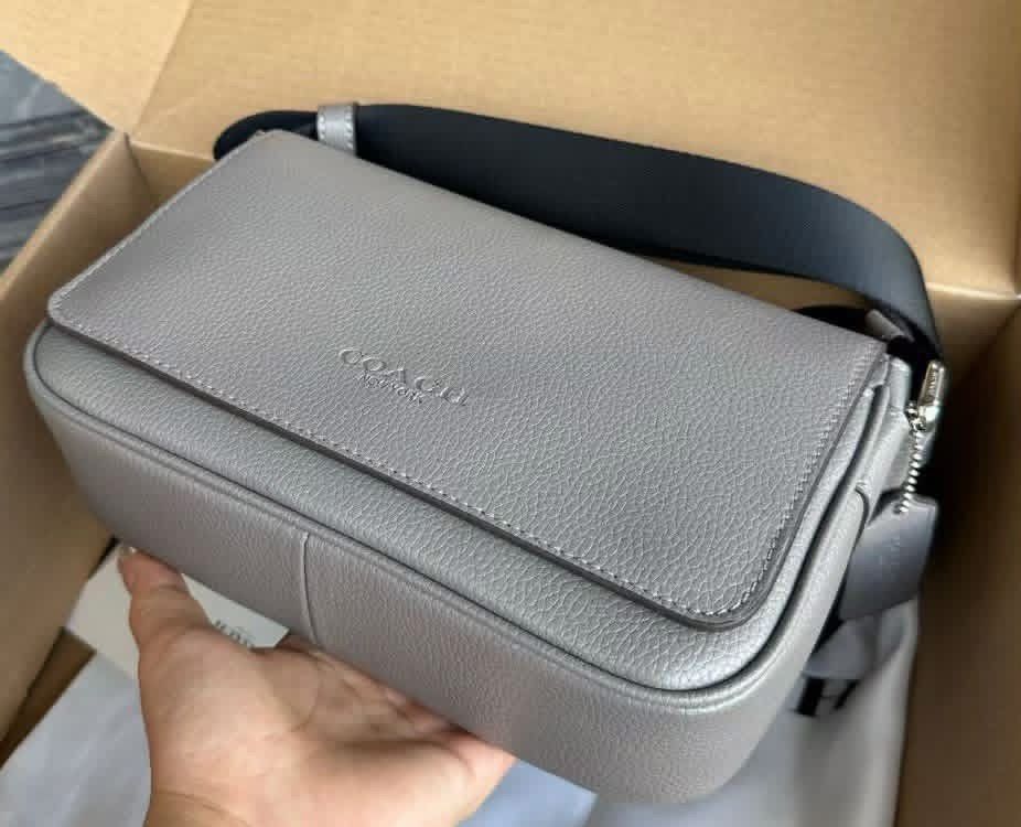 Coach Grey Leather Crossbody Bag (Category: Sling Bags) located in Manila. Submitted by bagsandmanymanymore1 (Listing ID 1466986863, Image 2). Description: - Authentic Coach crossbody bag in grey pebbled leather - Adjustable black fabric strap for comfortable wear - Secure magnetic snap closure with front flap and embossed Coach logo - Silver-tone hardware and neat contrast stitching - Soft suede-lined interior with convenient slip pockets and le