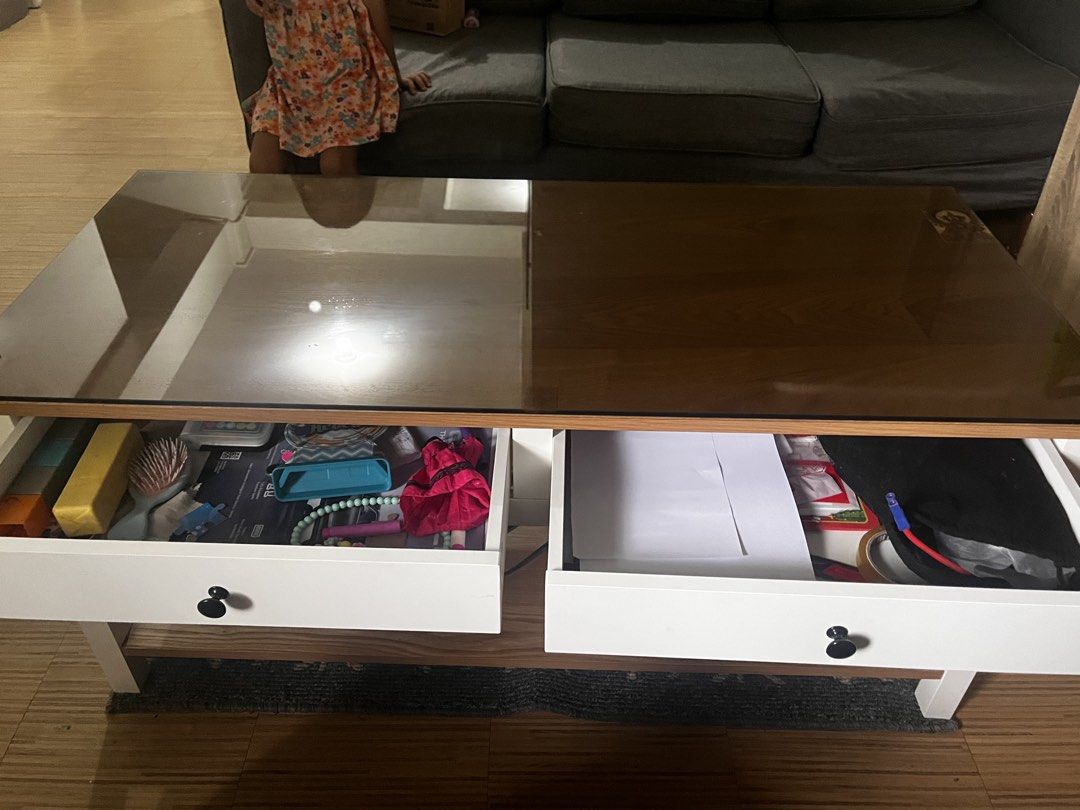 Coffee Table with Glass Top and Two Drawers (Category: Tables & Sets) located in Quezon City. Submitted by mcv1102 (Listing ID 1466982753, Image 2). Description: Free table top glass included na Wooden coffee table featuring a dark tinted glass top. Includes two white drawers with black round knobs for storage. Lower shelf provides extra space for keeping living room items organized. Sturdy white frame supports the entire structure..