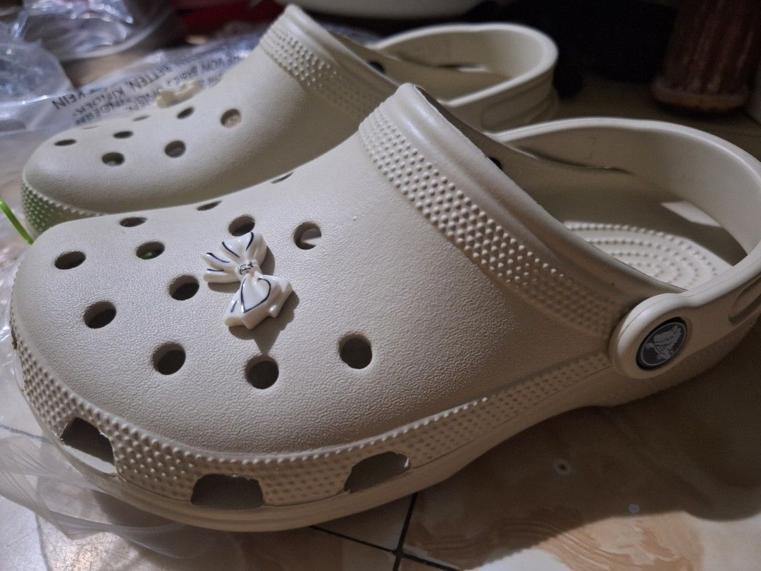 Crocs Classic Clog Bone With Bow Charms Size W6 (Category: Slippers and slides) located in Cavite. Submitted by lilltevg (Listing ID 1467068265, Image 3). Description: - Brand: Crocs Classic Clogs - Color: Bone - Size: US Women's 6 (W6) - Condition: Brand new with original tags - Inclusions: White and black bow Jibbitz charms attached - Material: Lightweight foam, slip-on comfort - Origin: Made in Vietnam - Best for: Casual wear and everyday erra
