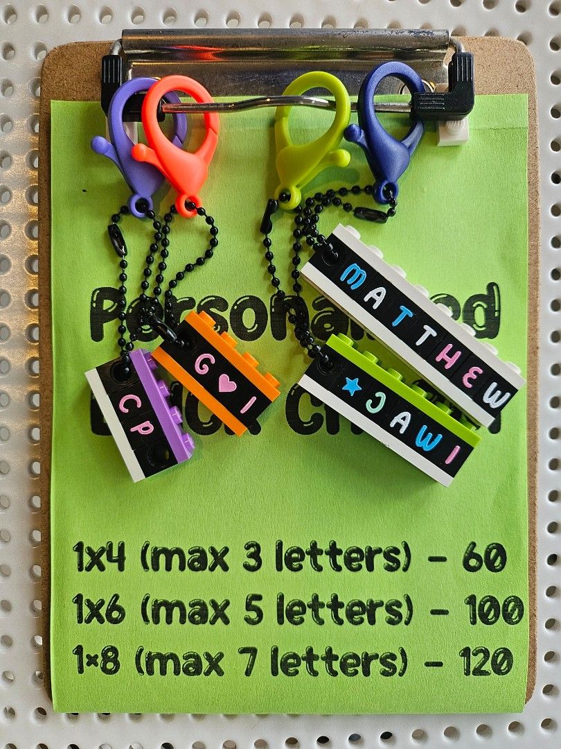 Custom Lego Brick Name Charms (Category: Lego & Building Sets) located in Quezon City. Submitted by thebrickingpoint (Listing ID 1467024466, Image 1). Description: Custom brick charms made from Lego bricks and parts with custom text and symbols. 1x4 - P60 (max 3 letters) 1x6 - P100 (max 5 letters) 1x8 - P120 (max 7 letters) Each brick charm includes a colored clasp and black ball chain. Brick letters available in mint, pink, blue and white colors