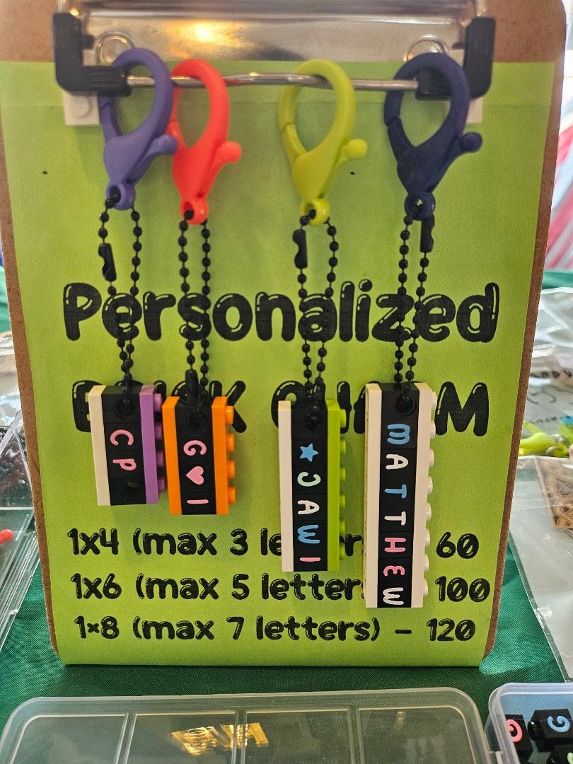 Custom Lego Brick Name Charms (Category: Lego & Building Sets) located in Quezon City. Submitted by thebrickingpoint (Listing ID 1467024466, Image 2). Description: Custom brick charms made from Lego bricks and parts with custom text and symbols. 1x4 - P60 (max 3 letters) 1x6 - P100 (max 5 letters) 1x8 - P120 (max 7 letters) Each brick charm includes a colored clasp and black ball chain. Brick letters available in mint, pink, blue and white colors