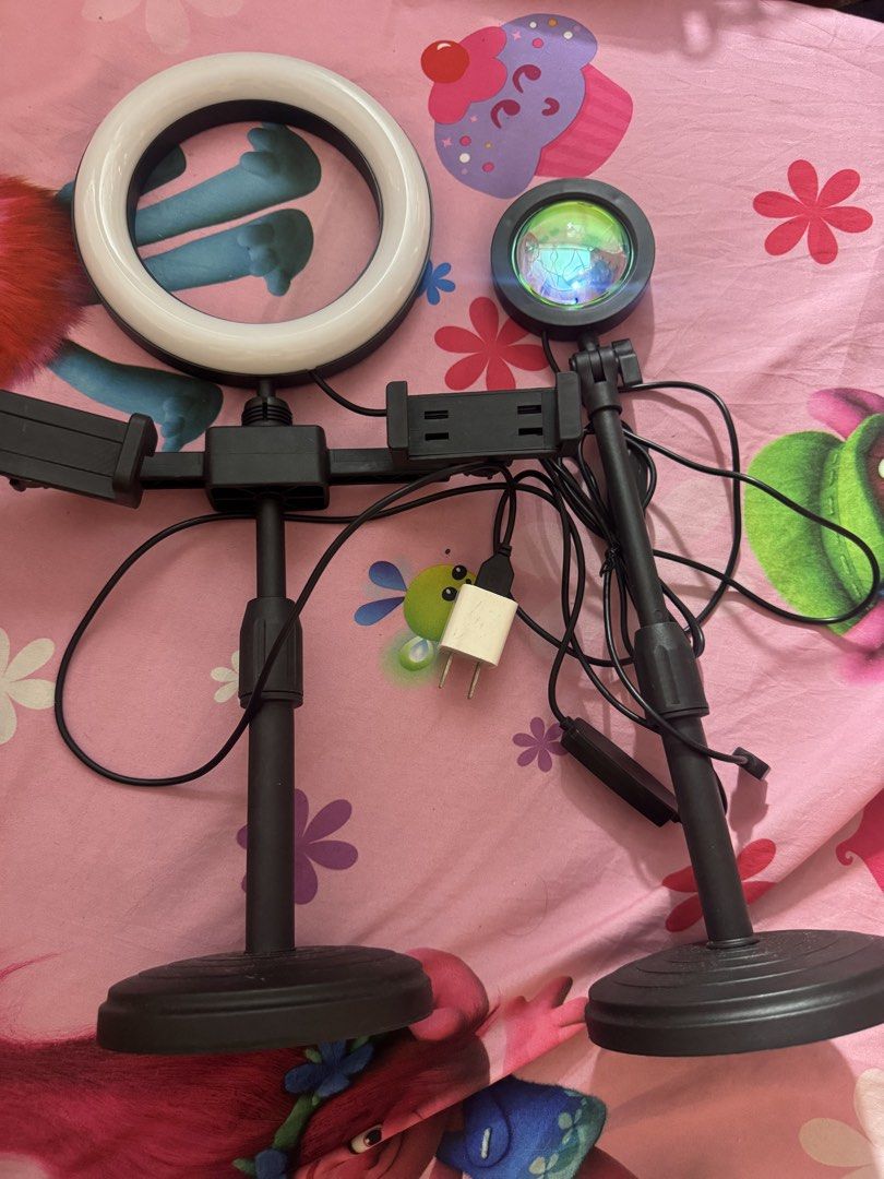 Desktop Ring Light and Sunset Projection Lamp Set (Category: Lighting) located in Manila. Submitted by vitadolcebella (Listing ID 1467089072, Image 2). Description: IM SELLING MY LIGHTS Sunset Lamp 150 and Ring Light Dual Phone Holder 500! (600 po bili ko sa Ayala Malls Feliz) Hindi pa gamit both. - Dual desktop stands with sturdy weighted round bases - Left side: White ring light with phone holder - Right side: Colorful sunset projection lamp wi