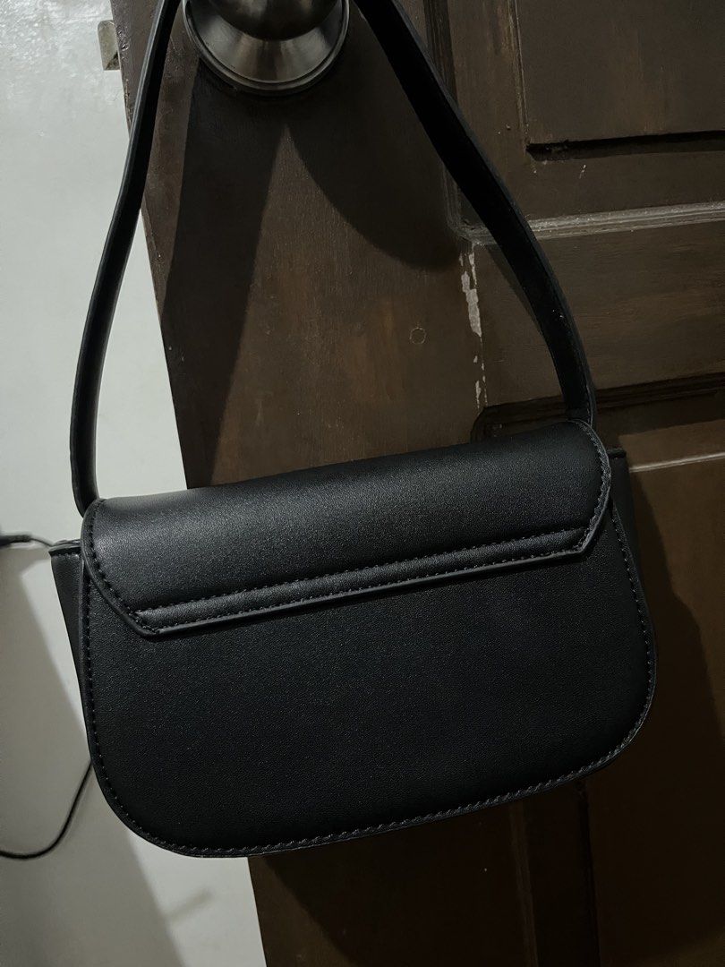 Diesel Black Oval D Logo Shoulder Bag (Category: Shoulder Bags) located in Mabalacat. Submitted by onlygrail.pamp (Listing ID 1467143969, Image 2). Description: Black leather shoulder bag from Diesel. Silver hardware with prominent metal Oval D logo on the front flap. Magnetic snap closure. Interior lined with black fabric and features a leather brand patch plus slip pocket. Clean structure with sturdy strap attached by metal rings..