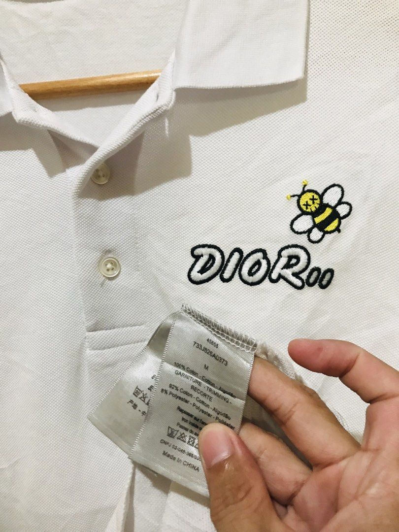 Dior Bee Embroidered White Polo Shirt (Category: Luxury Apparel) located in Rizal. Submitted by drthrifttwo (Listing ID 1466975973, Image 1). Description: - Brand: Dior - Item: Polo shirt with short sleeves and collar - Color: White - Size: Medium (21" chest x 27" length) - Material: Cotton and polyester blend - Design: Embroidered Dior logo and iconic Kaws bee patch on chest - Details: Two-button placket, made in China - Condition: Excellent / G
