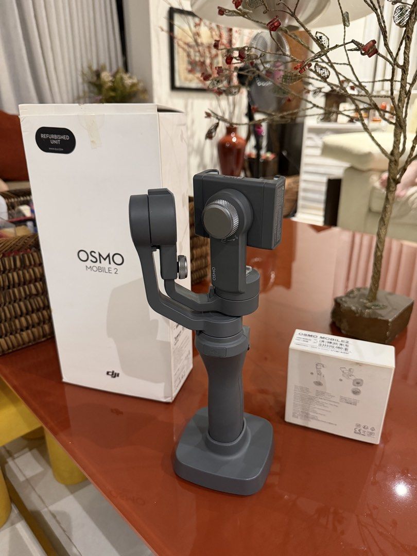 DJI Osmo Mobile 2 with Base (Category: Gimbals & Stabilizers ) located in Quezon City. Submitted by kyleddude007 (Listing ID 1467113878, Image 2). Description: - Item: DJI Osmo Mobile 2 Handheld Smartphone Stabilizer - Color: Gray - Condition: Refurbished unit (marked on packaging), fully tested and working - Inclusions: Original box and separate Osmo Mobile 2 base accessory - Features: Stands upright correctly on the base, perfect for smooth vid