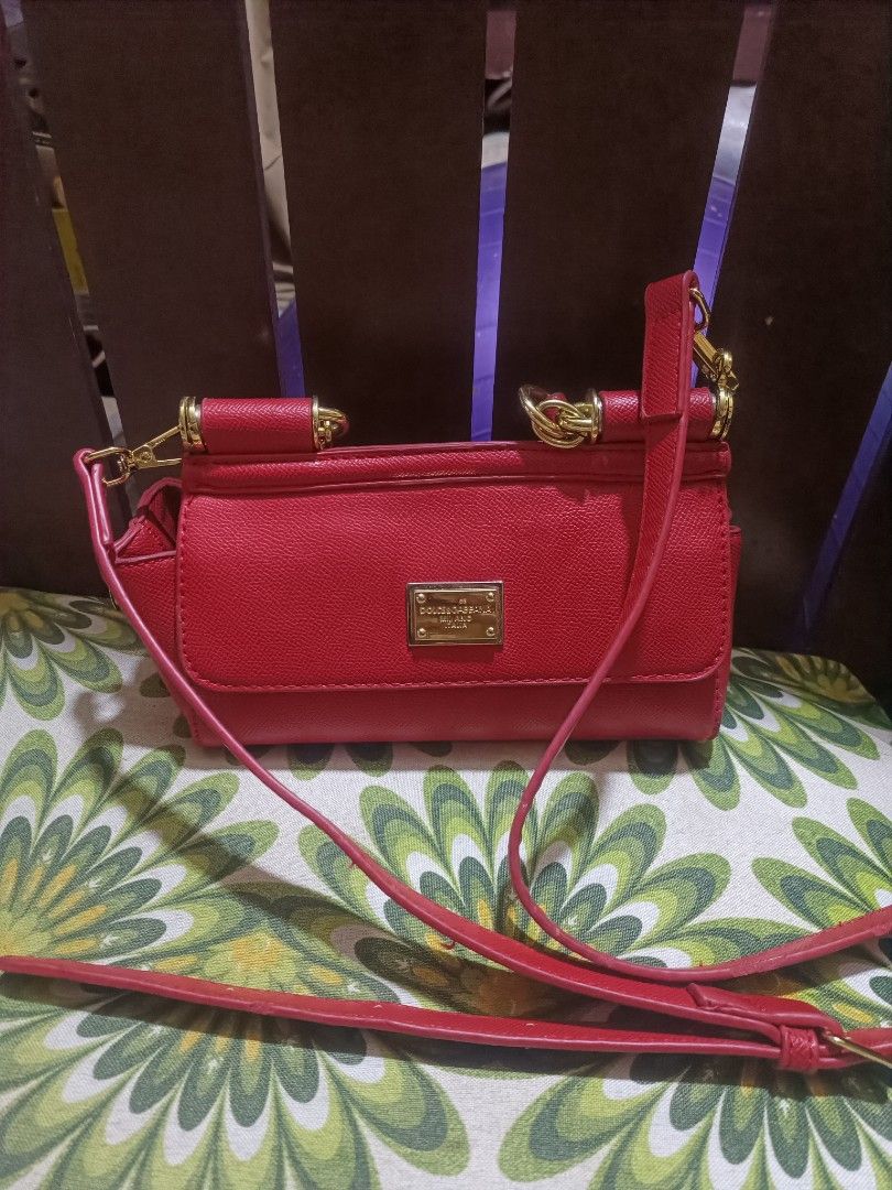 Dolce & Gabbana Red Leather Crossbody Bag (Category: Luxury Bags & Wallets) located in Cebu City. Submitted by elen30abalo (Listing ID 1467083729, Image 3). Description: - Color: Bright red with chic gold hardware accents - Material: Premium leather with a structured shape - Versatile: Includes a top handle and a matching detachable shoulder strap - Closure: Secure push-lock magnetic closure on the front flap - Interior: Fabric-lined with a conve