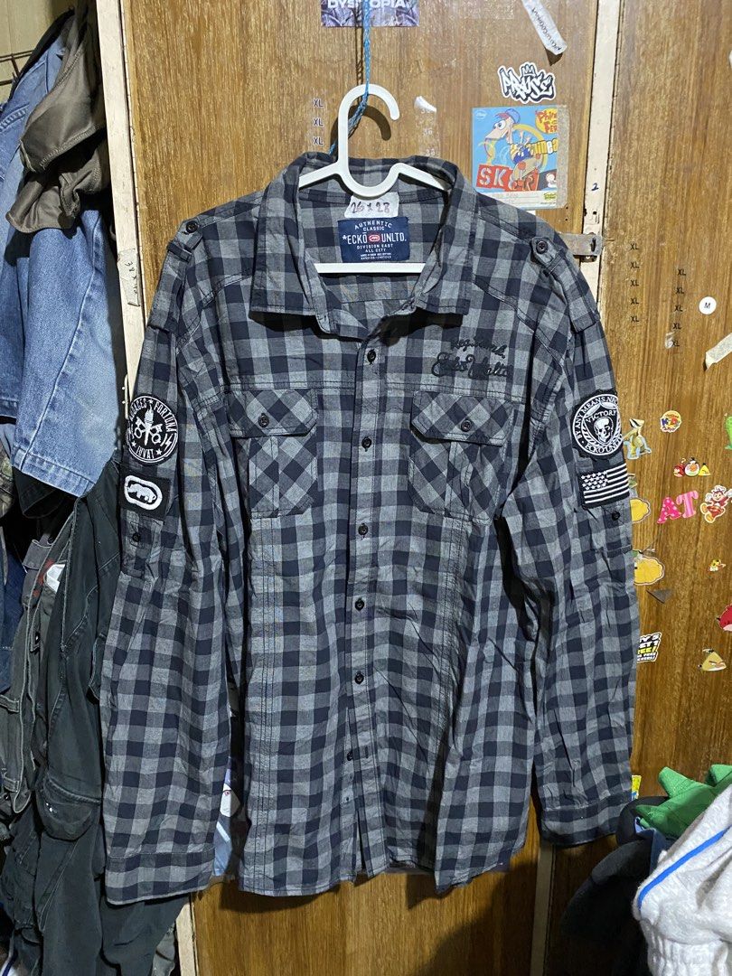 Ecko Unltd Black Grey Plaid Flannel Shirt Patchwork (Category: Tshirts & Polo Shirts ) located in Imus. Submitted by frootiloots4103 (Listing ID 1467153109, Image 1). Description: - Brand: Ecko Unltd - Style: Plaid flannel button-down shirt - Colorway: Black and grey check - 26x28 - Material: 100% cotton, made in India - Details: Dual chest pockets, embroidered skull and American flag patches on sleeves - Condition: Solid streetwear piece loaded 
